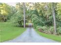 Long driveway leading to the property with lush greenery and mature trees on both sides at 2203 Arbor Hill Rd, Canton, GA 30115