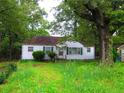 Charming one-story home with green shutters surrounded by mature trees and lush greenery at 244 Hilltop Sw Dr, Atlanta, GA 30315
