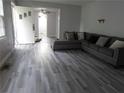 Gray-toned living room featuring modern wood-look floors, gray sofa and a ceiling fan at 244 Hilltop Sw Dr, Atlanta, GA 30315