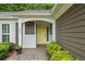 Close-up of the front entrance featuring a bright yellow door and decorative white trim at 245 Scotch Pine Ct, Alpharetta, GA 30022