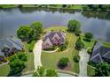 Stunning aerial view of a luxurious home with lush landscaping, lake view, and a private driveway at 1608 Mulberry Lake Dr, Dacula, GA 30019