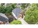 Aerial view of brick house with mature trees, paved driveway, and manicured lawn at 315 Hembree Grove Trce, Roswell, GA 30076