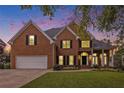 Attractive brick home with a well-maintained lawn, garage, and inviting entrance at dusk at 315 Hembree Grove Trce, Roswell, GA 30076