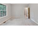 Neutrally painted bedroom with plush carpeting and bright window view at 2173 Pebble Beach Dr, Lawrenceville, GA 30043