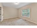 Carpeted bedroom with a large window overlooking the trees at 2173 Pebble Beach Dr, Lawrenceville, GA 30043