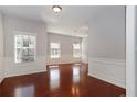 Dining room featuring wainscotting, cherry hardwood floors, and two large windows at 2173 Pebble Beach Dr, Lawrenceville, GA 30043