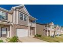 Well-maintained townhome exterior with landscaped front yard and attached garage at 7162 Fringe Flower Dr, Austell, GA 30168