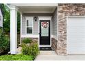 Stylish front entrance with stone detail, charming wreath, and well-maintained landscaping at 2939 Woodward Down Trl, Buford, GA 30519