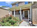Charming brick home with a covered front porch and beautiful landscaping at 4885 Maristone Landing Way, Cumming, GA 30040