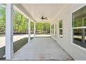 Covered patio features ceiling fan, offering a space for outdoor dining and relaxing with a view of the surrounding trees at 2749 Porches Ln, Dacula, GA 30019