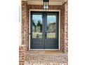 Elegant front door with glass panels, brick surround, and overhead light fixture at 4010 Sierra Knolls Ct, Cumming, GA 30040