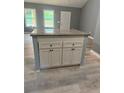 New kitchen island with granite countertop and grey cabinets gives a homey and simple yet modern vibe at 201 Deerfield Ln, Carrollton, GA 30116
