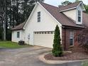 Spacious garage with white door and siding, complemented by a neatly maintained side yard at 300 Gaelic Way, Tyrone, GA 30290