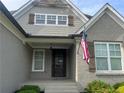 Close-up of a home's covered front entrance with an American flag waving by the front door at 312 Archway Ln, Peachtree City, GA 30269
