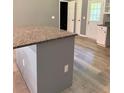 Kitchen island featuring a granite countertop, grey base with white trim, and modern electrical outlets at 191 Deerfield Ln, Carrollton, GA 30116