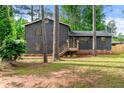 Charming two-story home with wood siding, shutters, stone foundation, and a cozy front porch with beautiful yard at 256 Grist Mill Ln, Lawrenceville, GA 30046