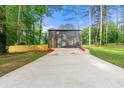 Rear view of the house with a long concrete driveway and well-maintained backyard at 256 Grist Mill Ln, Lawrenceville, GA 30046