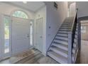 Bright entryway featuring hardwood floors, a staircase with gray accents, and a gray front door at 1265 Watercrest Cir, Lawrenceville, GA 30043