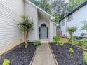 Inviting entrance with manicured garden beds leading to a gray front door at 1265 Watercrest Cir, Lawrenceville, GA 30043