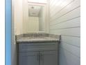 Stylish powder room with shiplap walls, granite countertop, and a gray vanity at 1265 Watercrest Cir, Lawrenceville, GA 30043