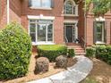 Elegant brick home featuring a detailed front entrance with decorative landscaping at 330 Broad Leaf Ct, Johns Creek, GA 30022