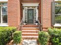 Inviting front porch with brick steps, wrought iron railings, and beautiful potted plants at 330 Broad Leaf Ct, Johns Creek, GA 30022
