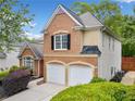 Side view of brick house with two-car garage and manicured landscaping at 604 Bassett Se Ct, Smyrna, GA 30080