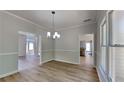 Bright dining room featuring hardwood floors, chair rail, and stylish lighting fixture at 6845 Gledhill Way, Stone Mountain, GA 30087