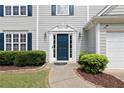 Welcoming front entrance with a dark teal door framed by sidelights and manicured shrubs, enhancing curb appeal at 2821 Amhurst Nw Way, Kennesaw, GA 30144