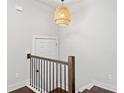 Bright hallway with hardwood floors, stylish lighting, and stairs with iron railing at 3760 Oxford Cir, Doraville, GA 30340