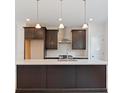 Modern kitchen with center island, stainless steel appliances, white subway tile backsplash, and dark cabinets at 1309 Bennett Creek Ovlk, Suwanee, GA 30024