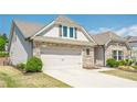 Lovely home featuring neutral siding, a two-car garage, stone details, and manicured landscaping at 3715 Bridges Ct, Cumming, GA 30040