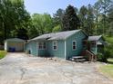 Charming home with a detached garage, picnic table, and ample parking on a sunny day at 6296 Longino Drive, Union City, GA 30291