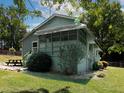 View of the home, showcasing the screened porch, picnic table, and lush lawn at 6296 Longino Drive, Union City, GA 30291