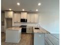 Bright kitchen boasts granite counters, an island, and modern stainless steel appliances at 1058 Crest Mill Dr, Marietta, GA 30008