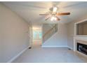 Living room boasts a fireplace, neutral carpet, and an open layout leading to a staircase and dining area at 107 Providence Run, Dallas, GA 30157