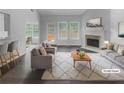 Bright, virtually staged living room with fireplace, hardwood floors, and large windows bringing in natural light at 4335 Northwind Dr, Ellenwood, GA 30294