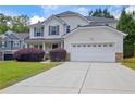 Inviting two-story home featuring a well-kept lawn, landscaped bushes, and attached two-car garage at 2951 Edgewater St, South Fulton, GA 30331