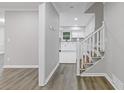 Bright entryway featuring gray walls and vinyl floors, leading to an open staircase and a view of the modern kitchen at 798 Brownlee Ln, Lawrenceville, GA 30044