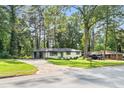 Attractive white brick home with a covered parking area, set amidst a lush, green landscape at 2425 Clifton Springs Rd, Decatur, GA 30034