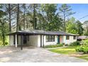 Inviting white brick home featuring a covered parking area and well-maintained landscaping at 2425 Clifton Springs Rd, Decatur, GA 30034