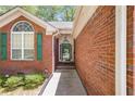 Inviting front entrance featuring a glass-paneled door and green shutters on the surrounding windows at 6718 Oakhurst Ct, Douglasville, GA 30134
