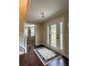 Inviting foyer with hardwood floors, decorative rug, and glass-paneled double entry doors at 6940 Treeline Dr, Cumming, GA 30028