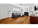 Cozy living room with hardwood floors, a fireplace, and a comfortable gray sofa at 131 Lively St, Norcross, GA 30071