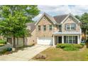 Two story home with brick and siding, featuring a manicured lawn and driveway leading to the 2-car garage at 1310 Scenic View Trce, Lawrenceville, GA 30044
