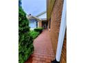 A red brick walkway leads to the home's entrance near a manicured yard and brick exterior at 4503 Hunters Ter, Stone Mountain, GA 30083