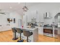 Stylish kitchen featuring an island with seating, stainless steel appliances, white cabinetry, and a modern range hood at 1497 Eason Nw St, Atlanta, GA 30314