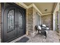 Inviting front porch with elegant double doors, brickwork, and seating area at 1136 Garner Creek At Parkview Sw Dr, Lilburn, GA 30047