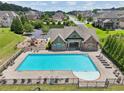 Aerial view of a large community pool, playground, and lounge chairs surrounded by lush greenery and neighborhood homes at 1136 Garner Creek Sw Dr, Lilburn, GA 30047
