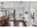 Bright dining room showcasing wood floors, modern light fixture, and large windows at 704 Woodbridge Dr, Woodstock, GA 30188